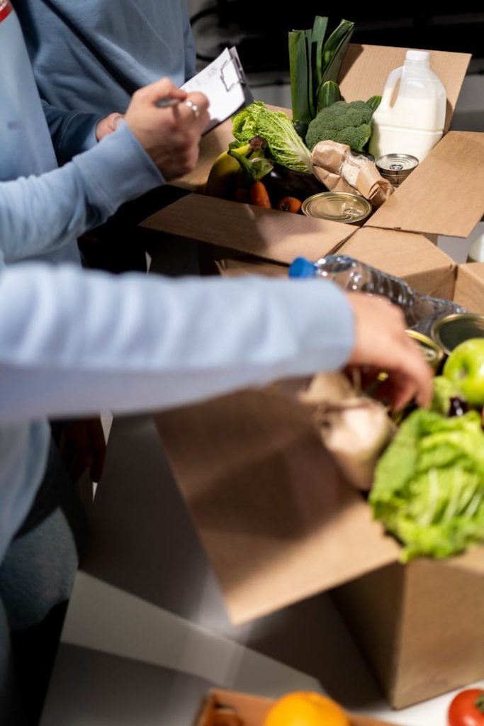 Volunteers organize fresh produce and canned goods for community distribution indoors.